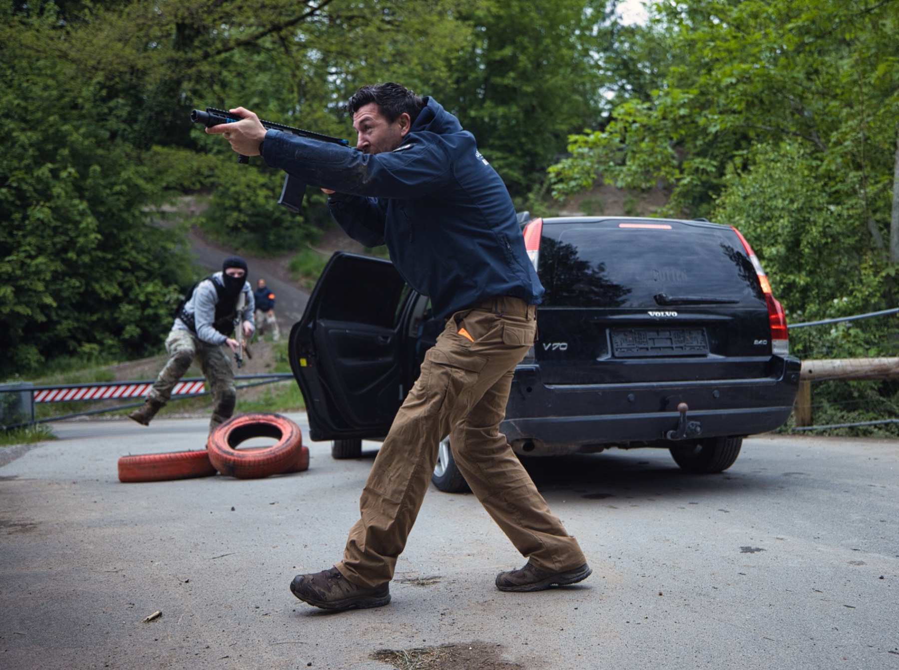 Armed role-player advancing on press vehicle