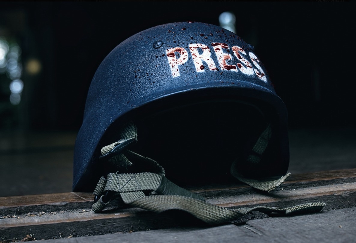 A blood-spattered PRESS helmet — the reality BLUESPEARHEAT training prepares journalists for
