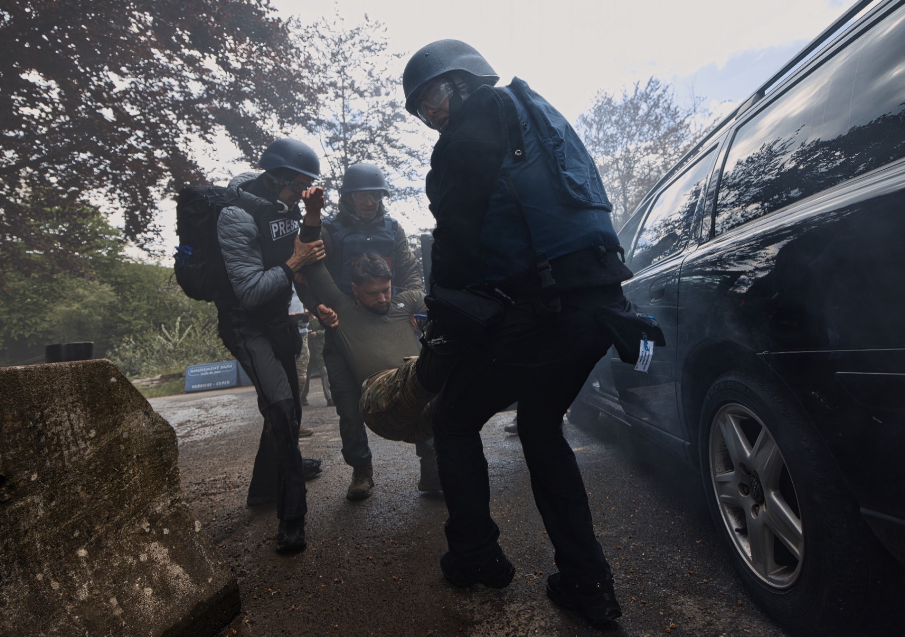 BLUESPEARHEAT team extracting a casualty past a vehicle during a HEAT field exercise